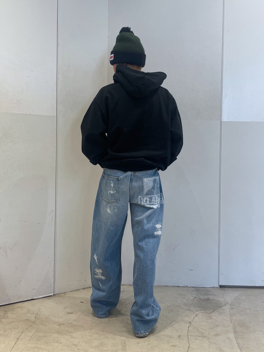 ブルー系のデニムパンツ、ブラック系のパーカー、グリーン系のニットキャップ/ビーニーを着用したメンズの秋コーディネートの3枚目の写真