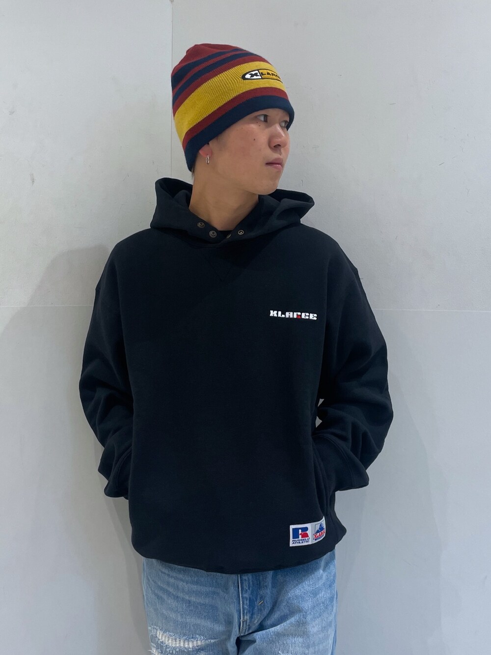 ブルー系のデニムパンツ、ブラック系のパーカー、レッド系のニットキャップ/ビーニーを着用したメンズの秋コーディネートの5枚目の写真