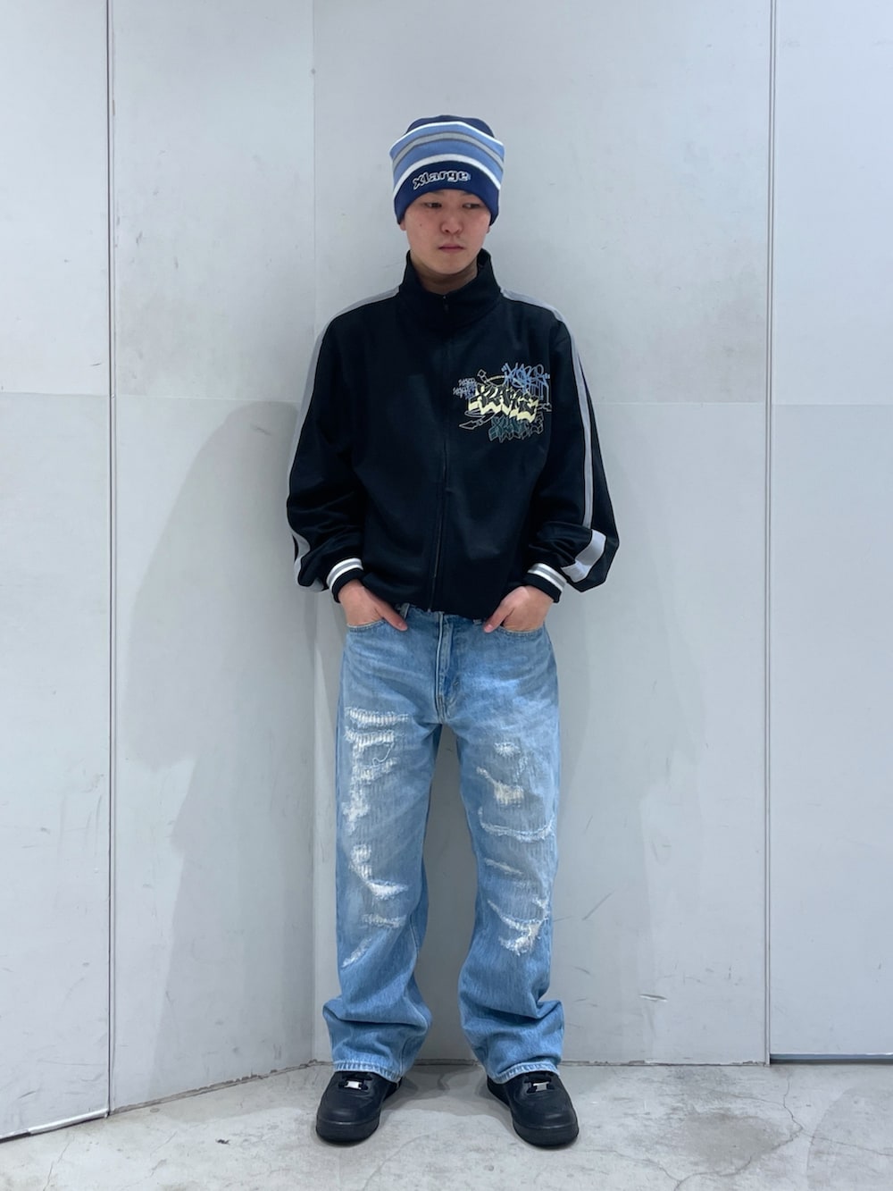 ブラック系のブルゾン、ブルー系のデニムパンツ、ブルー系のニットキャップ/ビーニーを着用したメンズの冬コーディネートの4枚目の写真