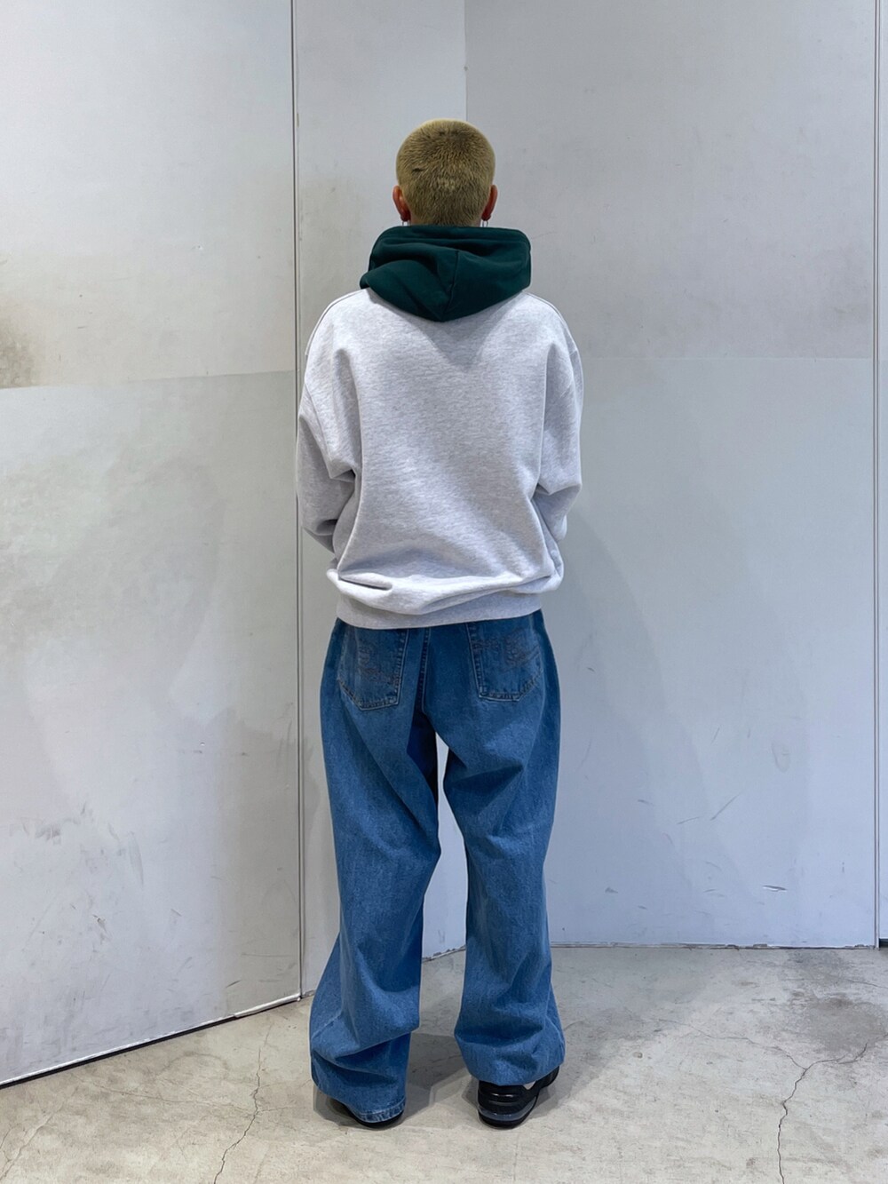 グレー系のパーカー、ブルー系のデニムパンツを着用したメンズの秋コーディネートの3枚目の写真