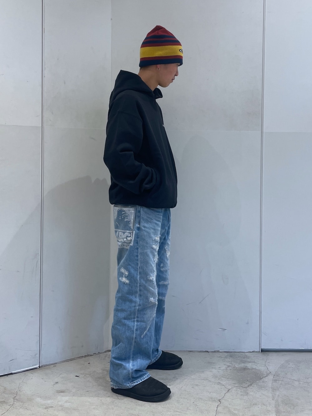 ブルー系のデニムパンツ、ブラック系のパーカー、レッド系のニットキャップ/ビーニーを着用したメンズの秋コーディネートの2枚目の写真