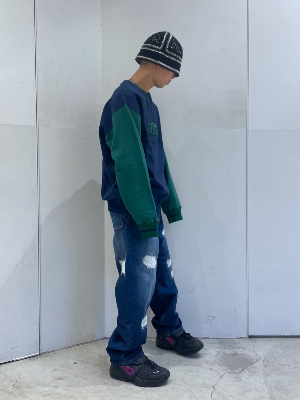 ブルー系のデニムパンツ、グリーン系のスウェットを着用したメンズの冬コーディネートの2枚目の写真