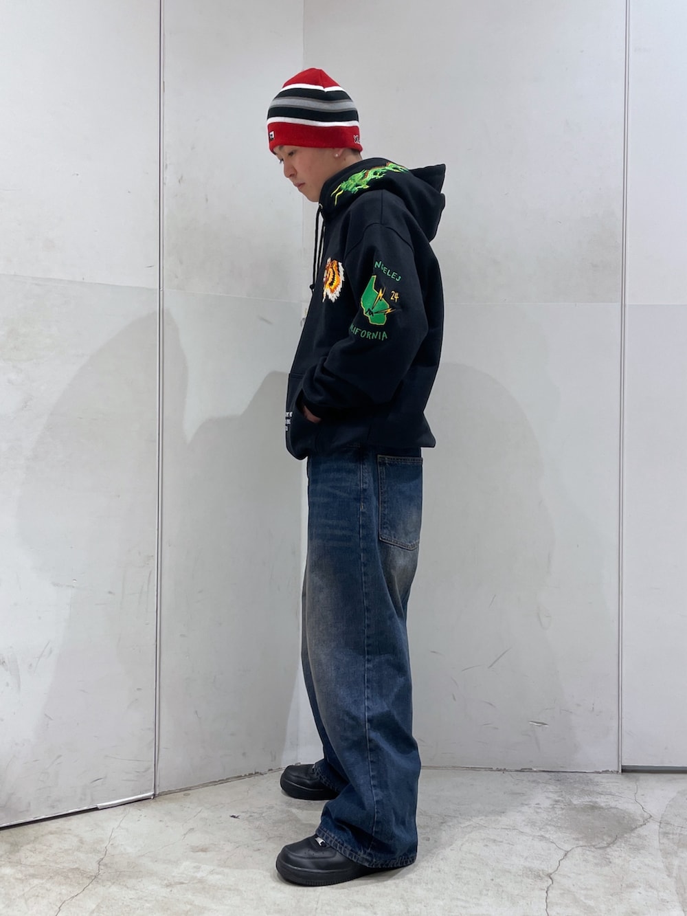 ブラック系のパーカー、ブルー系のデニムパンツ、ブラック系のニットキャップ/ビーニーを着用したメンズの冬コーディネートの4枚目の写真