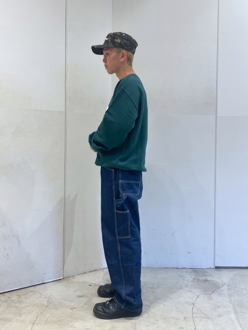 グリーン系のスウェット、ブルー系のデニムパンツを着用したメンズの秋コーディネートの5枚目の写真