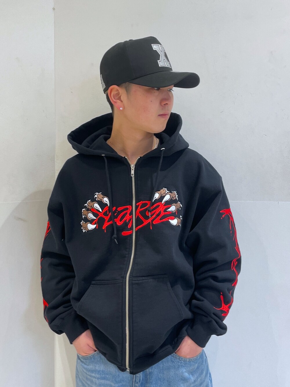 ブラック系のパーカー、ブルー系のデニムパンツを着用したメンズの冬コーディネートの5枚目の写真