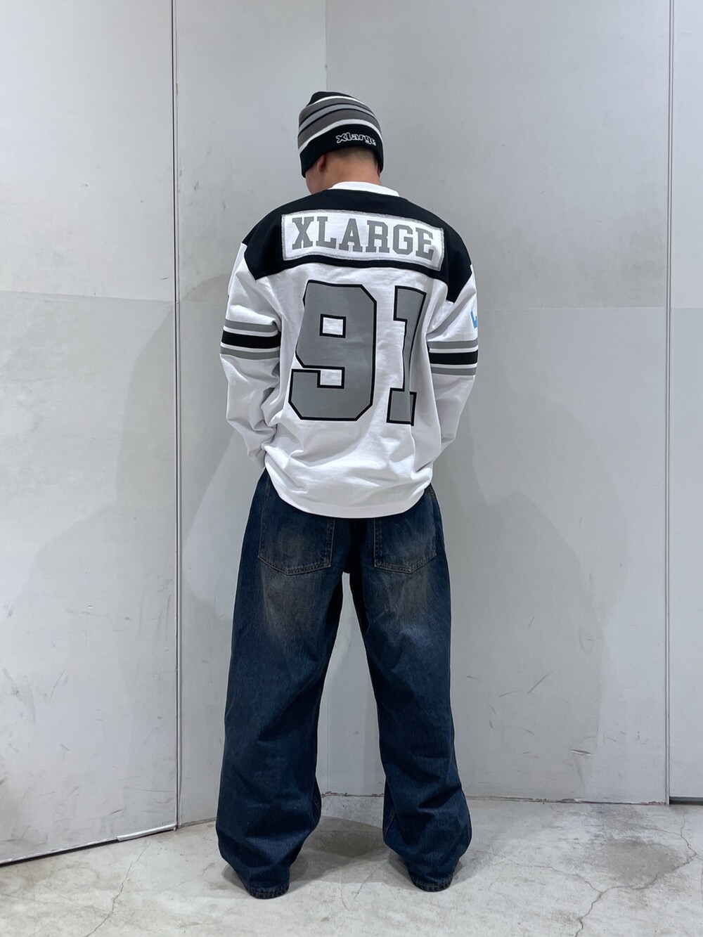 ホワイト系のTシャツ/カットソー、ブルー系のデニムパンツ、ブラック系のニットキャップ/ビーニーを着用したメンズの冬コーディネートの3枚目の写真