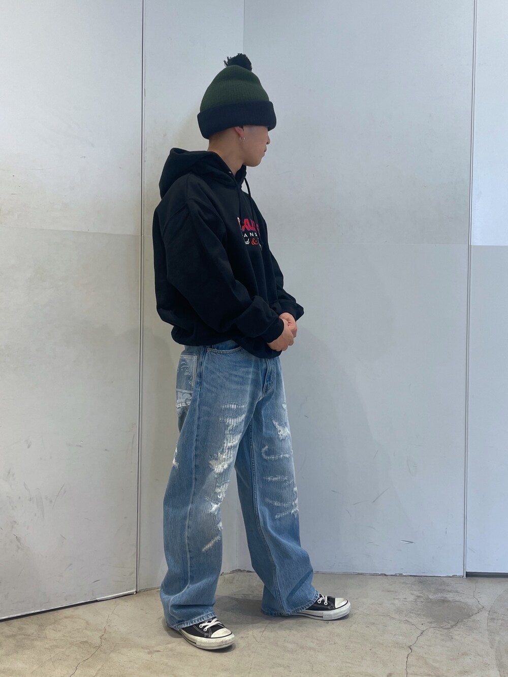 ブルー系のデニムパンツ、ブラック系のパーカー、グリーン系のニットキャップ/ビーニーを着用したメンズの秋コーディネートの2枚目の写真