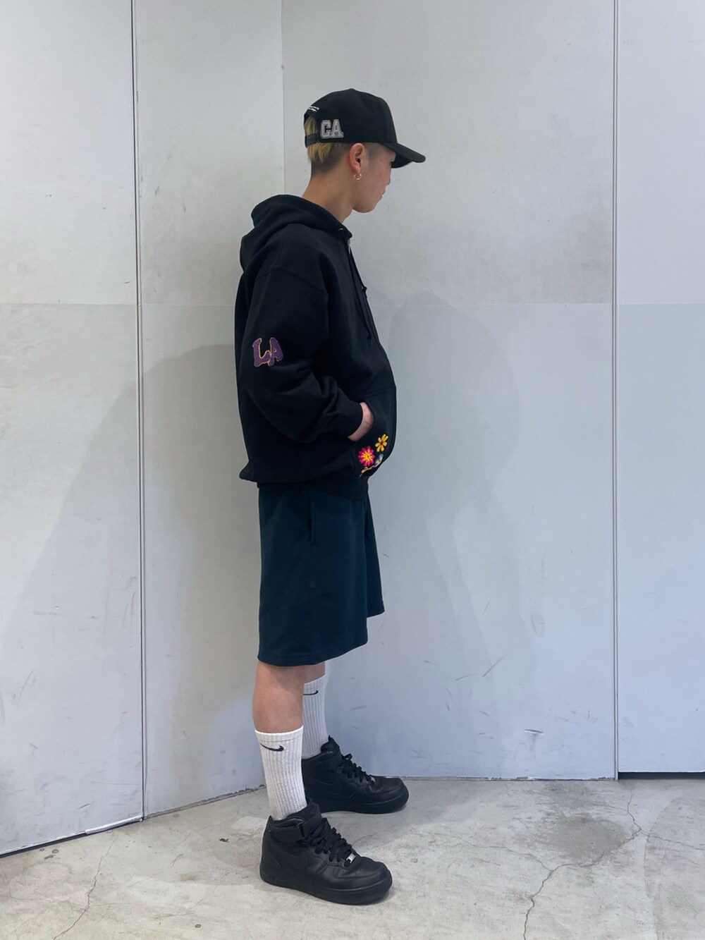 ブラック系のパーカー、ブルー系のスウェットパンツを着用したメンズの春コーディネートの2枚目の写真