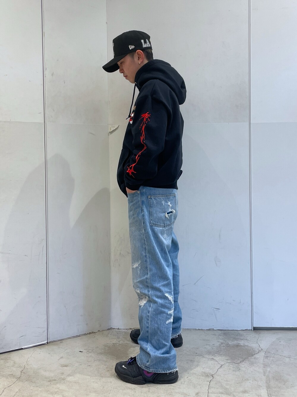 ブラック系のパーカー、ブルー系のデニムパンツを着用したメンズの冬コーディネートの4枚目の写真