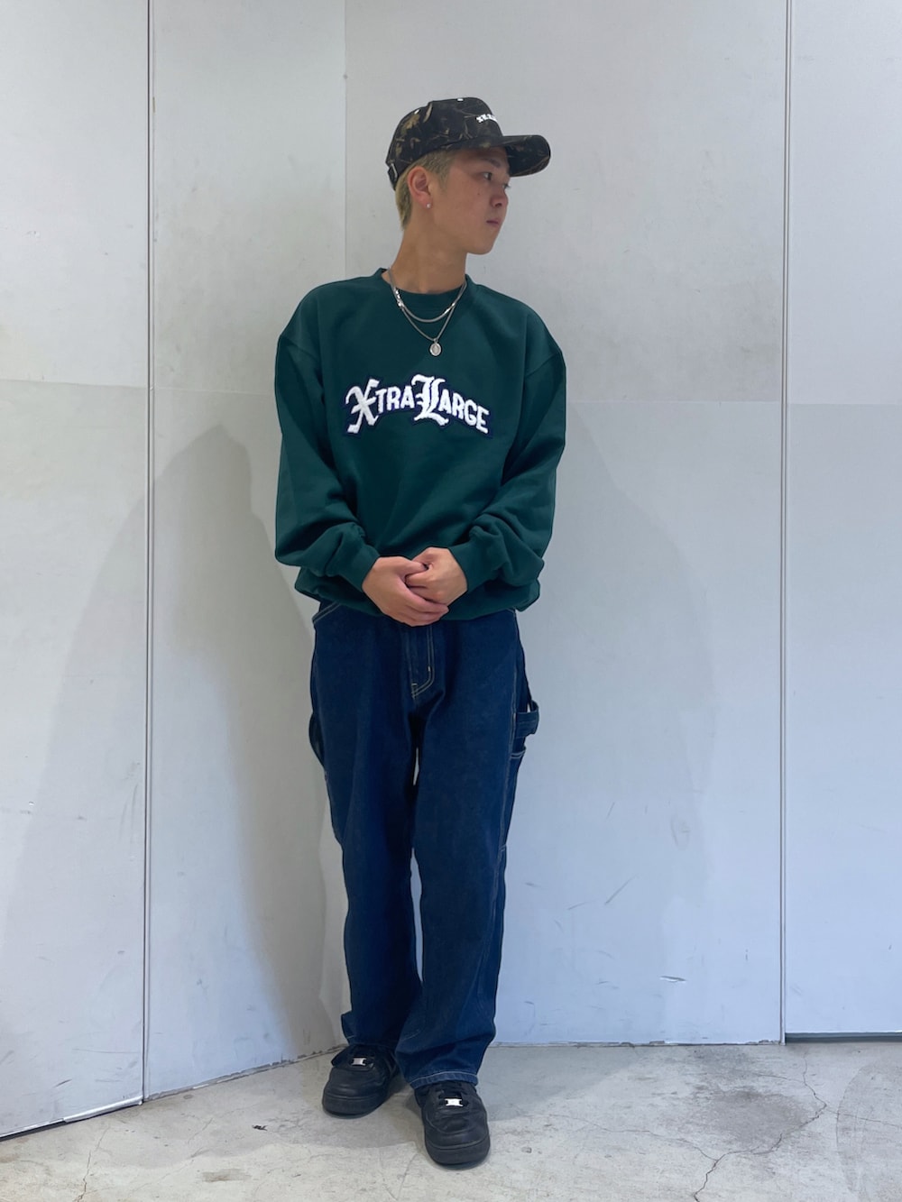 グリーン系のスウェット、ブルー系のデニムパンツを着用したメンズの秋コーディネートの2枚目の写真