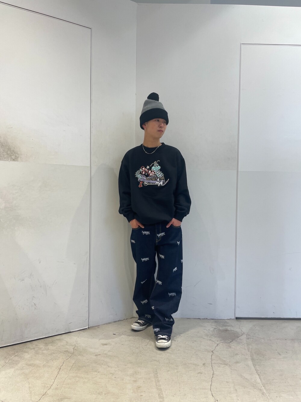 ブラック系のスウェット、ブルー系のデニムパンツ、グレー系のニットキャップ/ビーニーを着用したメンズの秋コーディネートの2枚目の写真