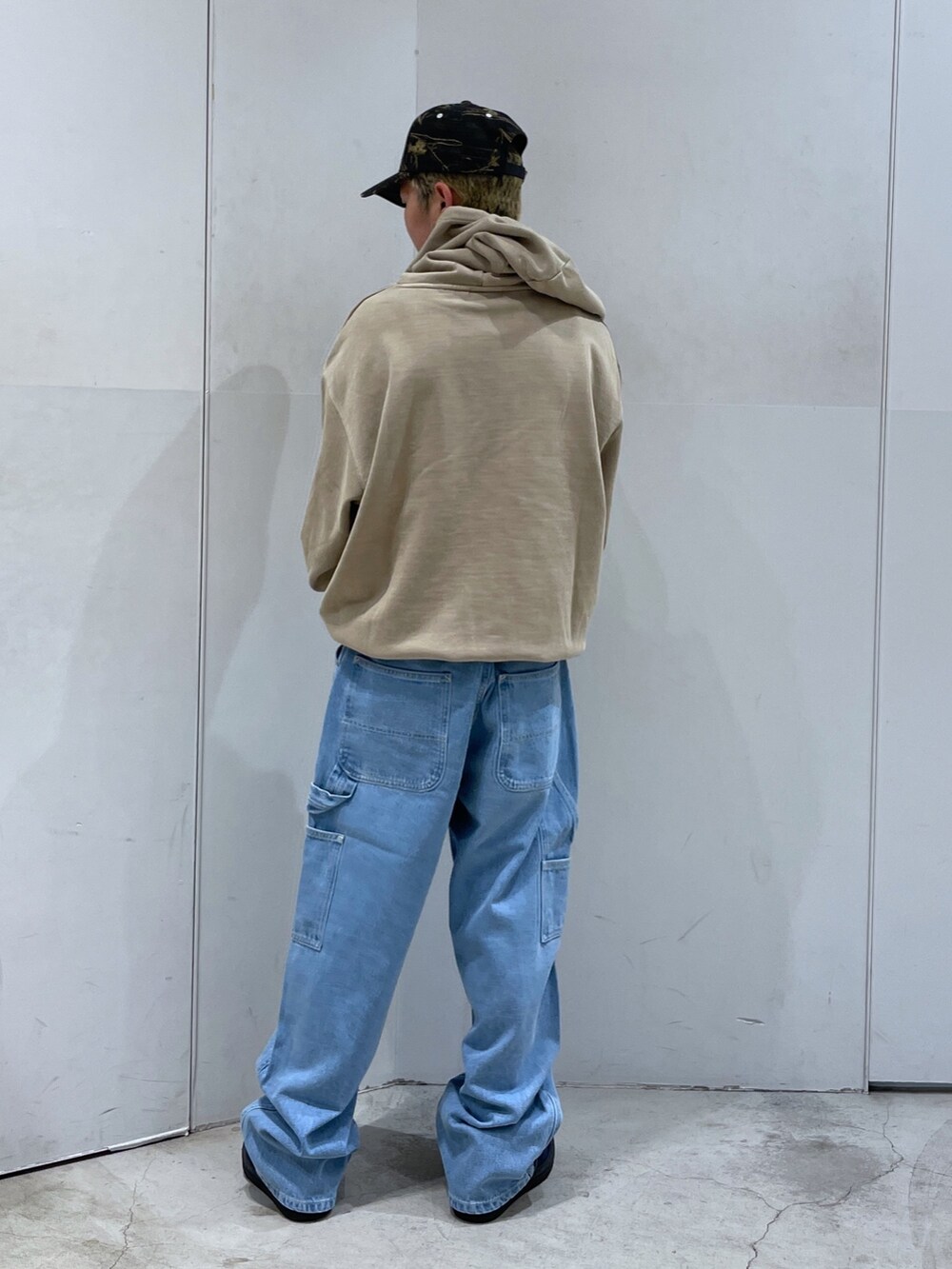 ベージュ系のパーカー、ブルー系のデニムパンツを着用したメンズの秋コーディネートの3枚目の写真