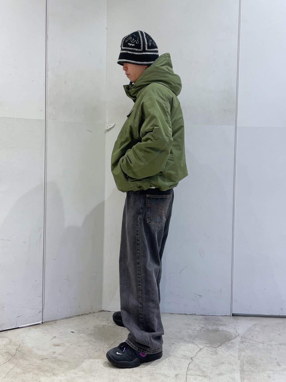 グリーン系のその他アウター、ブラック系のハットを着用したメンズの冬コーディネートの4枚目の写真