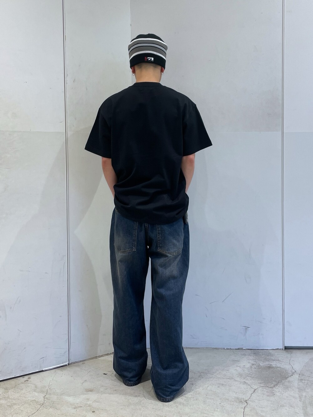 ブラック系のTシャツ/カットソー、ブルー系のデニムパンツ、ブラック系のニットキャップ/ビーニーを着用したメンズの春コーディネートの3枚目の写真