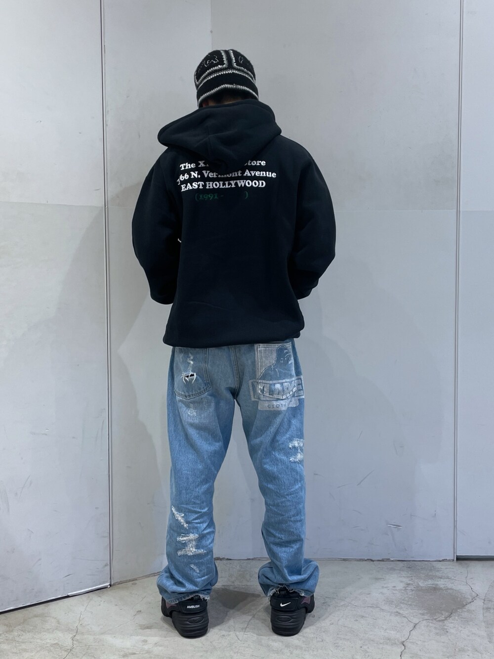 ブラック系のパーカー、ブルー系のデニムパンツ、ブラック系のハットを着用したメンズの冬コーディネートの3枚目の写真