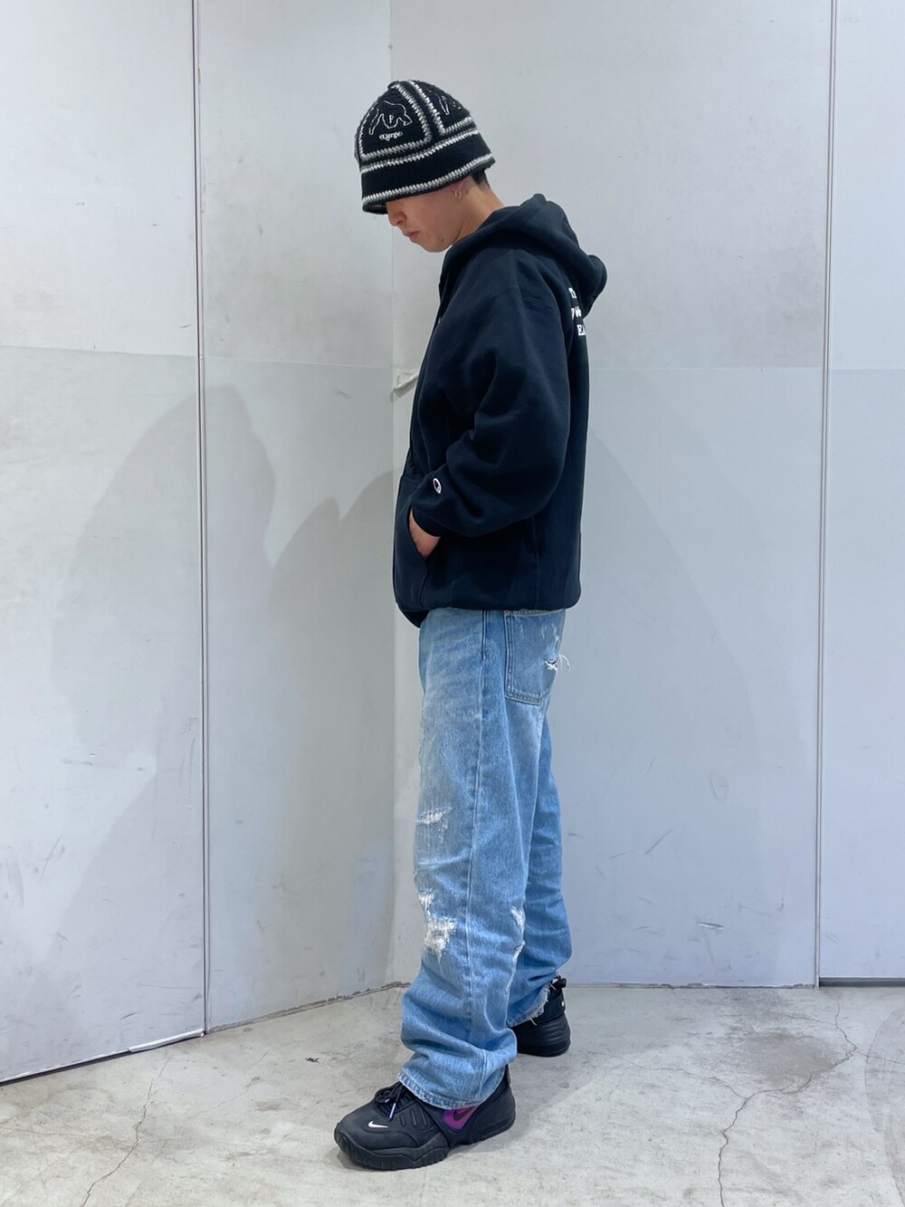 ブラック系のパーカー、ブルー系のデニムパンツ、ブラック系のハットを着用したメンズの冬コーディネートの4枚目の写真