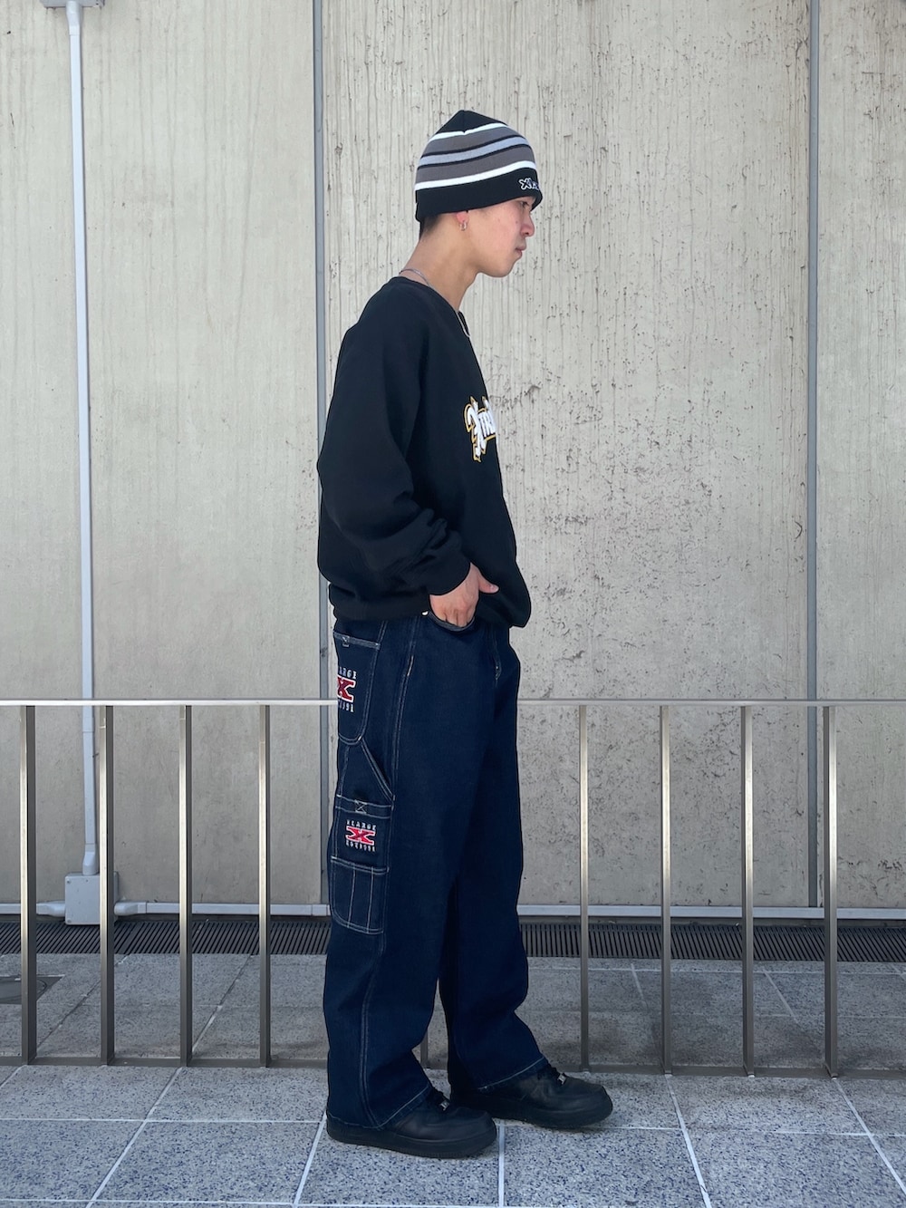 ブラック系のスウェット、ブルー系のデニムパンツ、ブラック系のニットキャップ/ビーニーを着用したメンズの春コーディネートの2枚目の写真