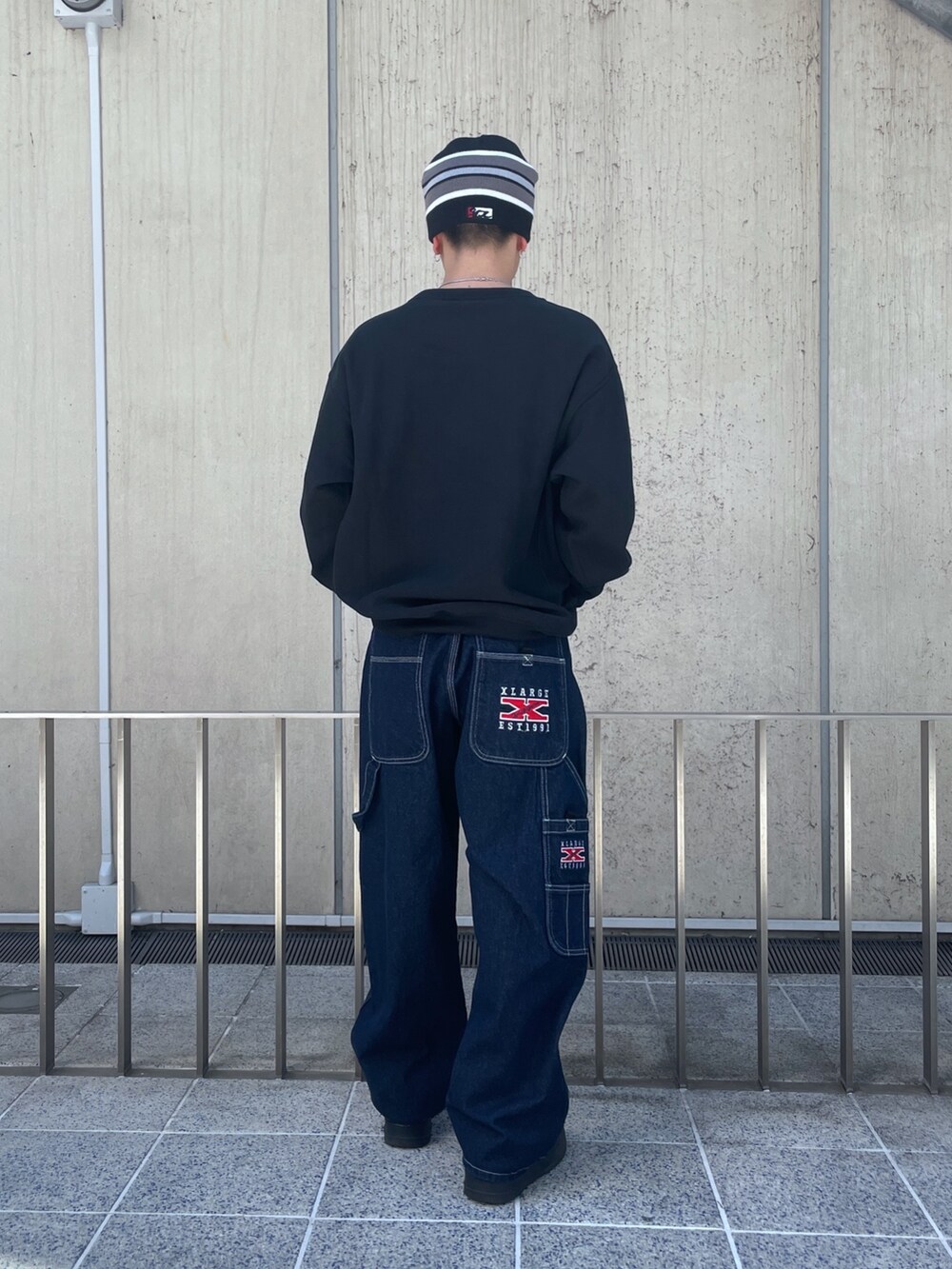 ブラック系のスウェット、ブルー系のデニムパンツ、ブラック系のニットキャップ/ビーニーを着用したメンズの春コーディネートの3枚目の写真