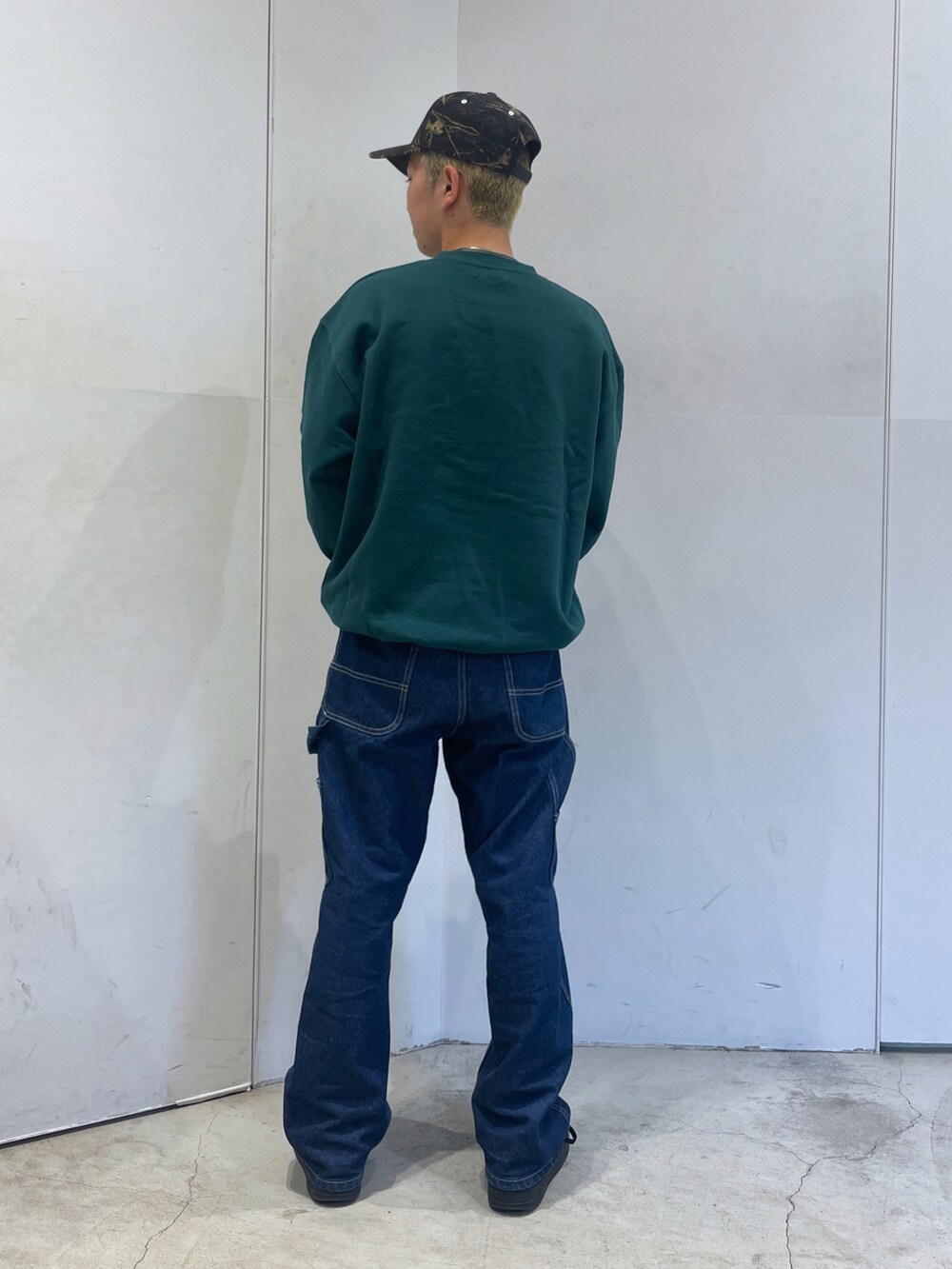 グリーン系のスウェット、ブルー系のデニムパンツを着用したメンズの秋コーディネートの4枚目の写真