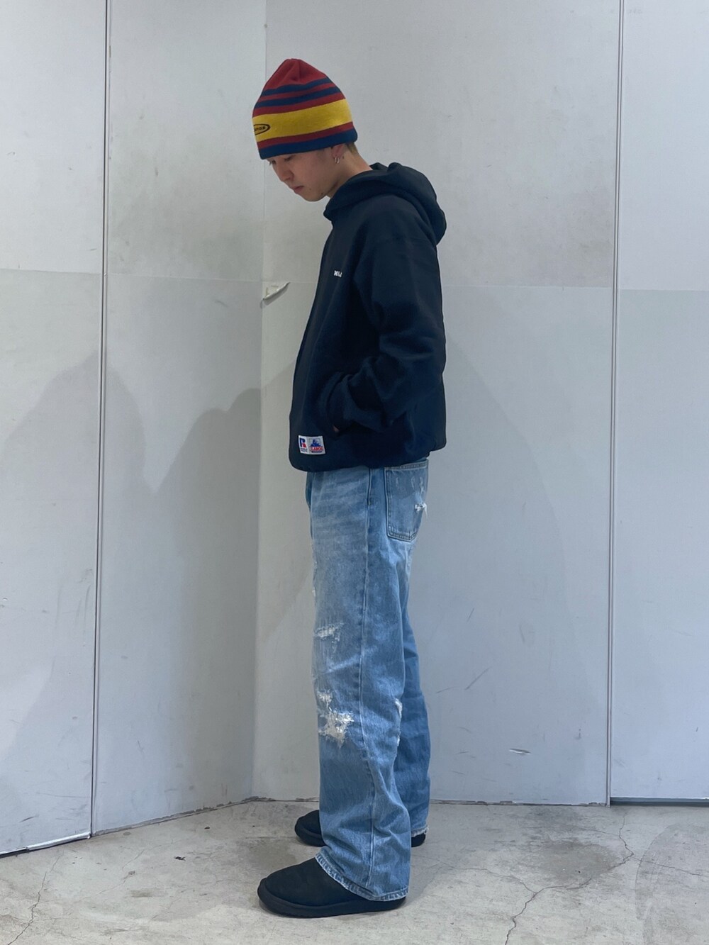 ブルー系のデニムパンツ、ブラック系のパーカー、レッド系のニットキャップ/ビーニーを着用したメンズの秋コーディネートの4枚目の写真