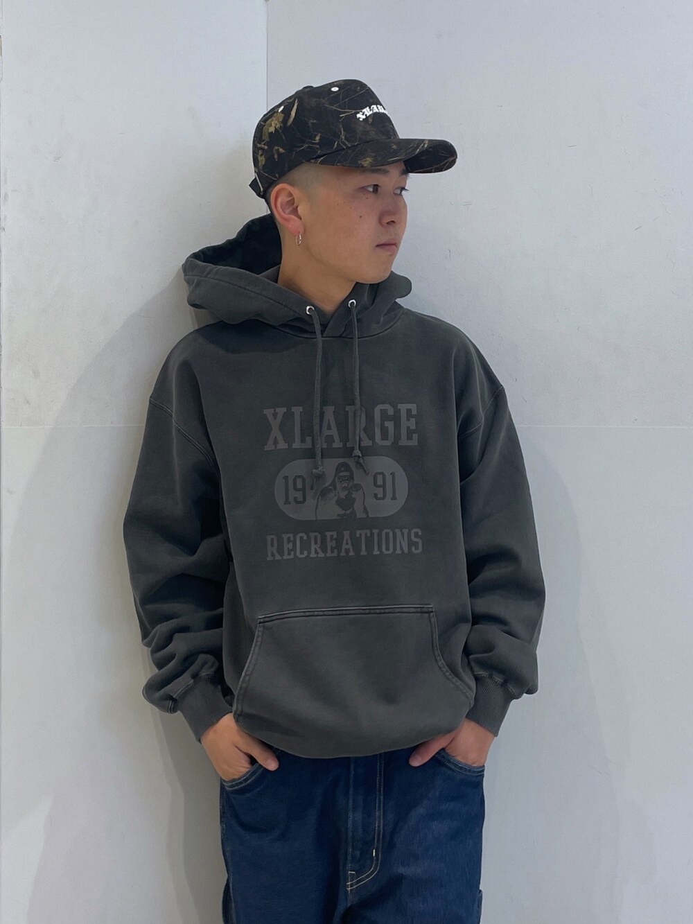 ブラック系のパーカー、ブルー系のデニムパンツを着用したメンズの秋コーディネートの5枚目の写真