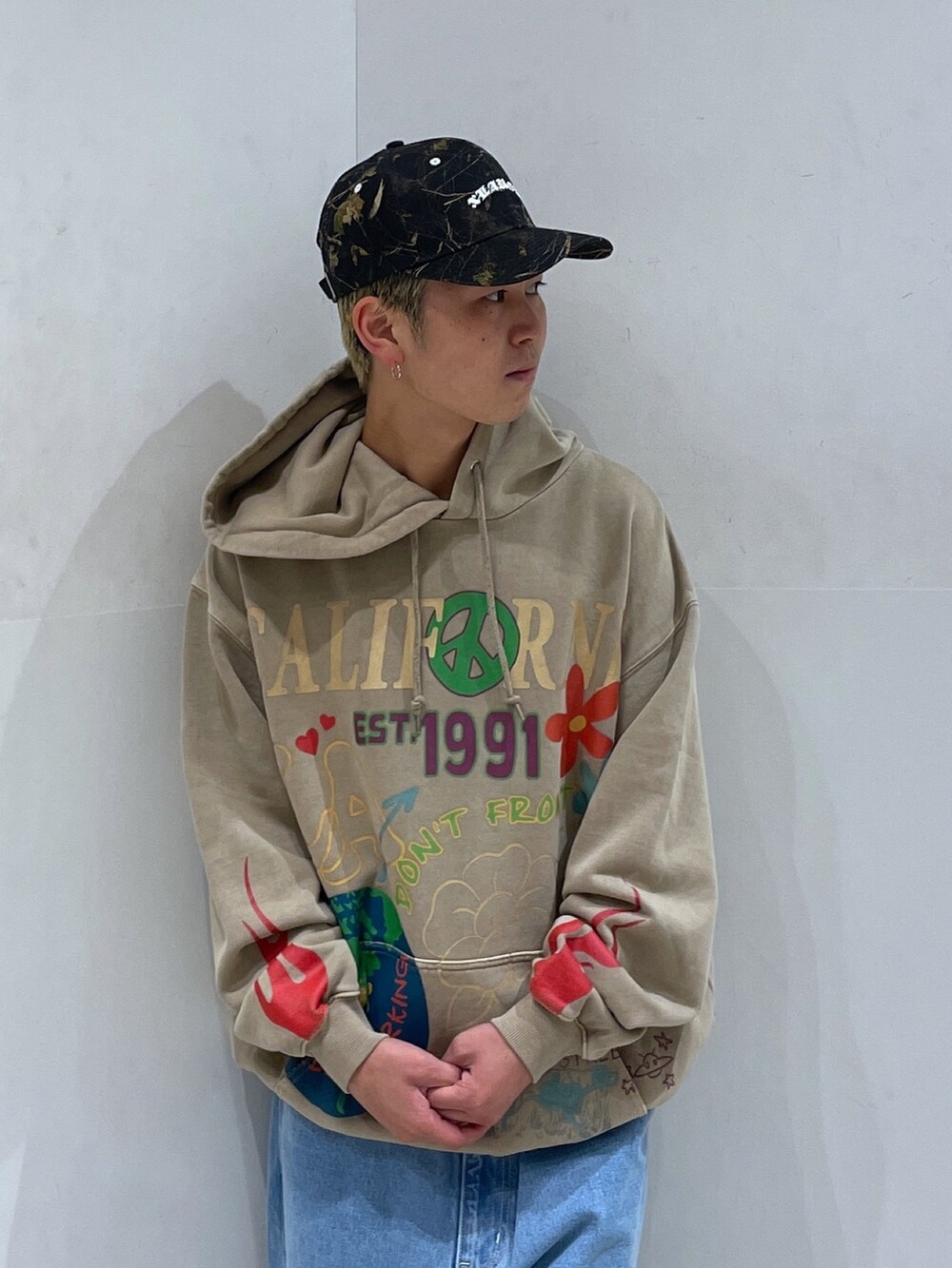 ベージュ系のパーカー、ブルー系のデニムパンツを着用したメンズの秋コーディネートの5枚目の写真