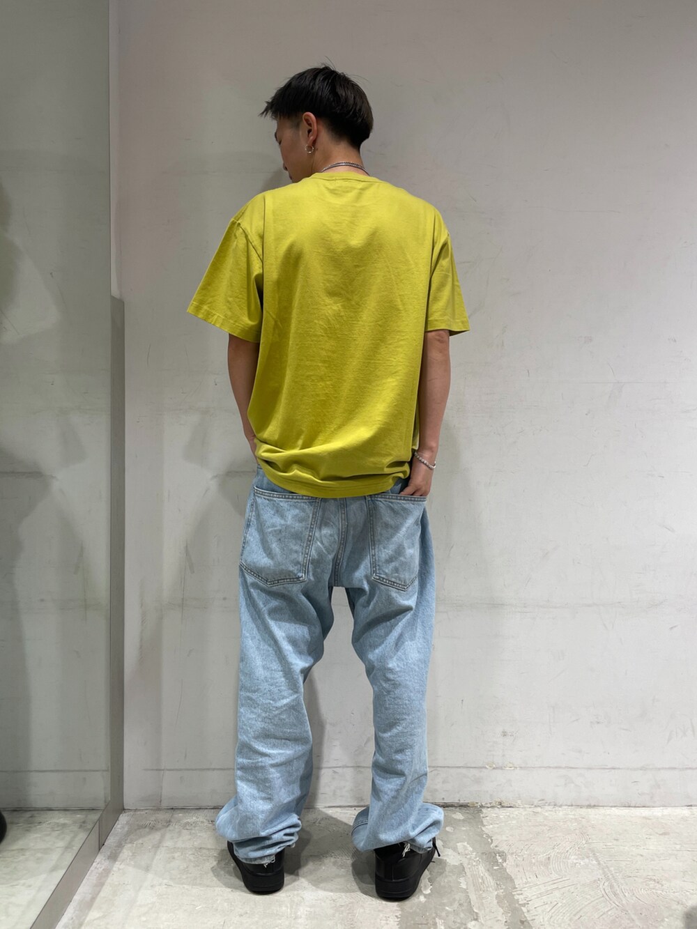 イエロー系のTシャツ/カットソー、ブルー系のデニムパンツ、ブラック系のスニーカーを着用したメンズの夏コーディネートの2枚目の写真