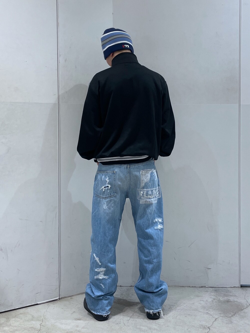 ブラック系のブルゾン、ブルー系のデニムパンツ、ブルー系のニットキャップ/ビーニーを着用したメンズの冬コーディネートの2枚目の写真