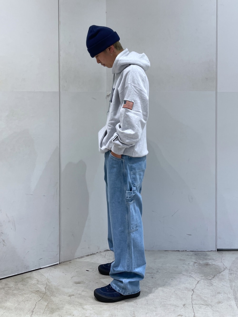 グレー系のパーカー、ブルー系のデニムパンツを着用したメンズの秋コーディネートの3枚目の写真