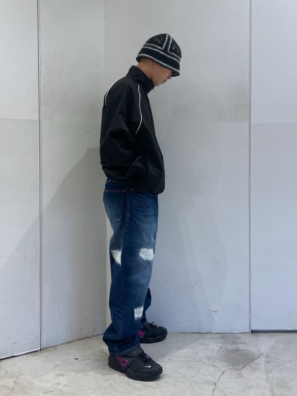 ブラック系のナイロンジャケット、ブルー系のデニムパンツを着用したメンズの冬コーディネートの2枚目の写真