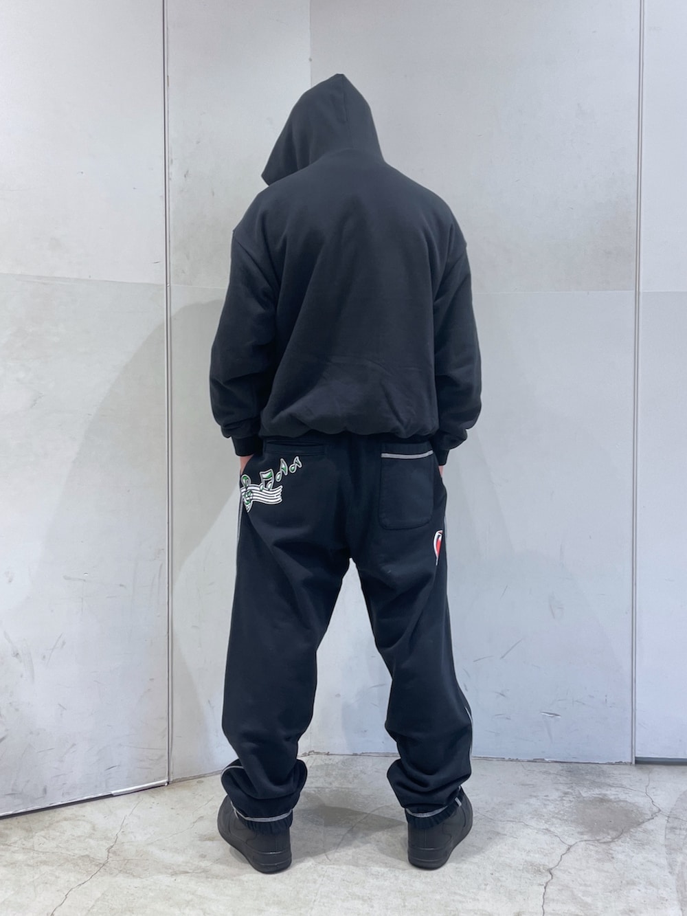 ブラック系のパーカー、ブラック系のスウェットパンツを着用したメンズの冬コーディネートの3枚目の写真