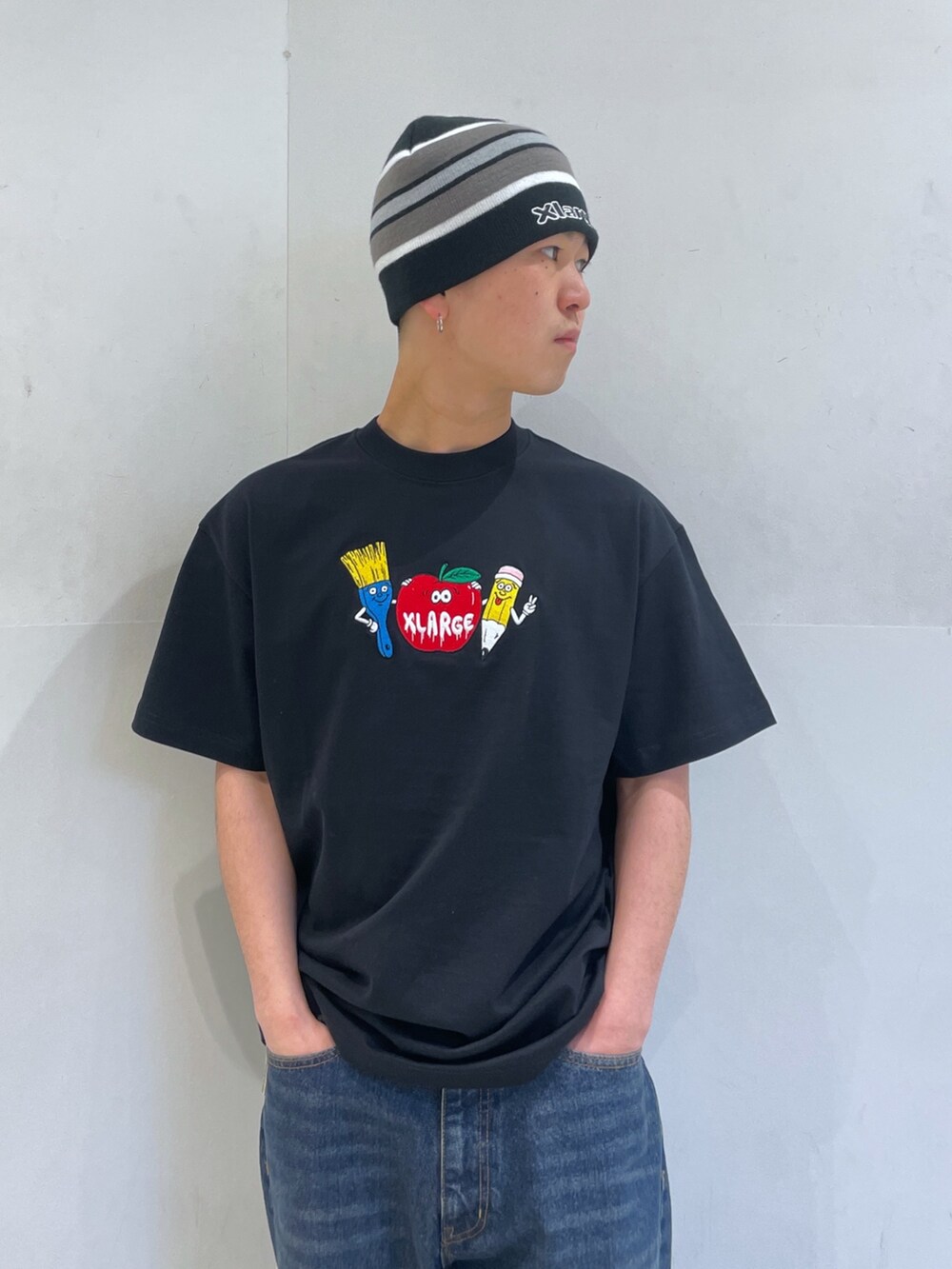 ブラック系のTシャツ/カットソー、ブルー系のデニムパンツ、ブラック系のニットキャップ/ビーニーを着用したメンズの春コーディネートの5枚目の写真