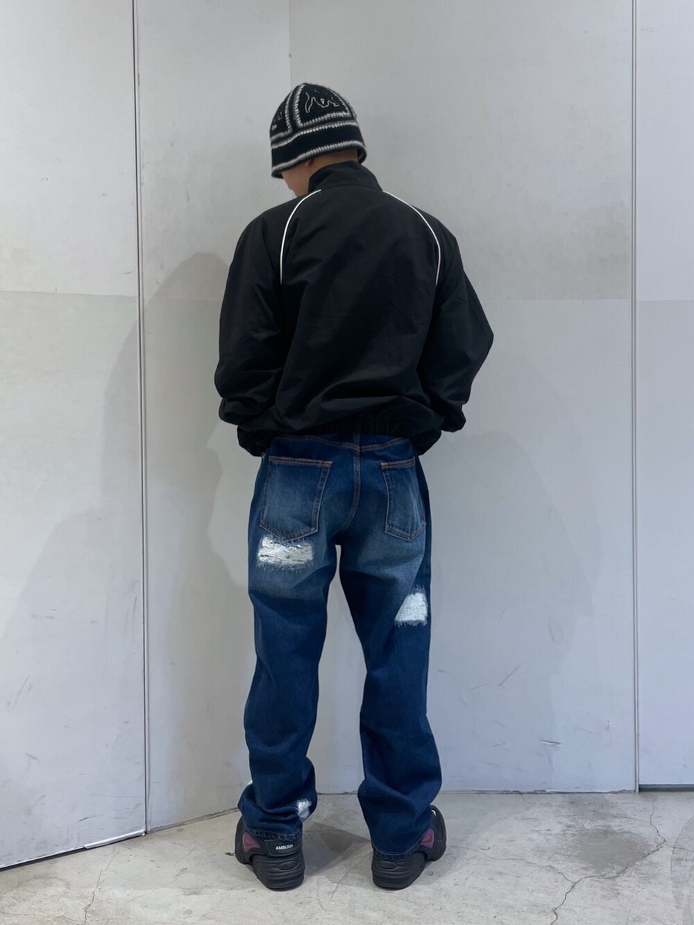 ブラック系のナイロンジャケット、ブルー系のデニムパンツを着用したメンズの冬コーディネートの3枚目の写真