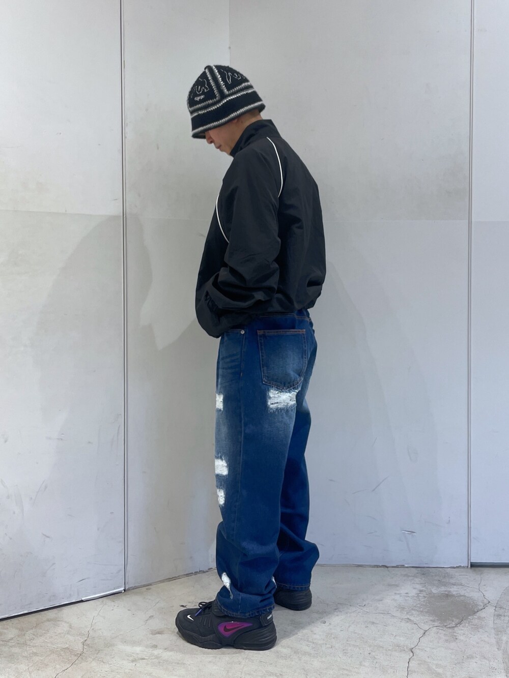 ブラック系のナイロンジャケット、ブルー系のデニムパンツを着用したメンズの冬コーディネートの4枚目の写真