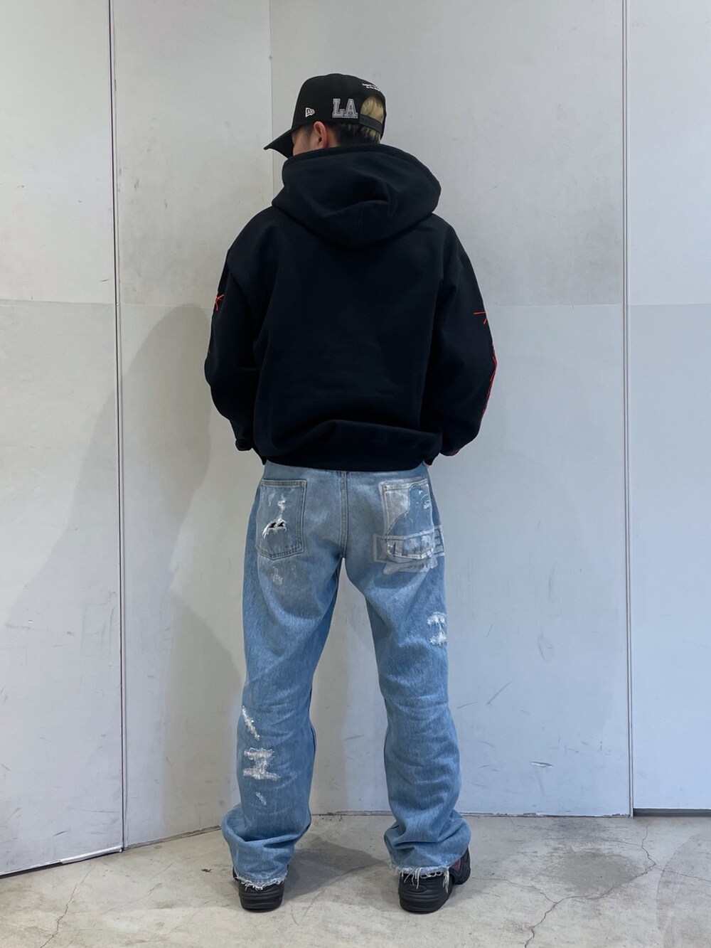 ブラック系のパーカー、ブルー系のデニムパンツを着用したメンズの冬コーディネートの3枚目の写真