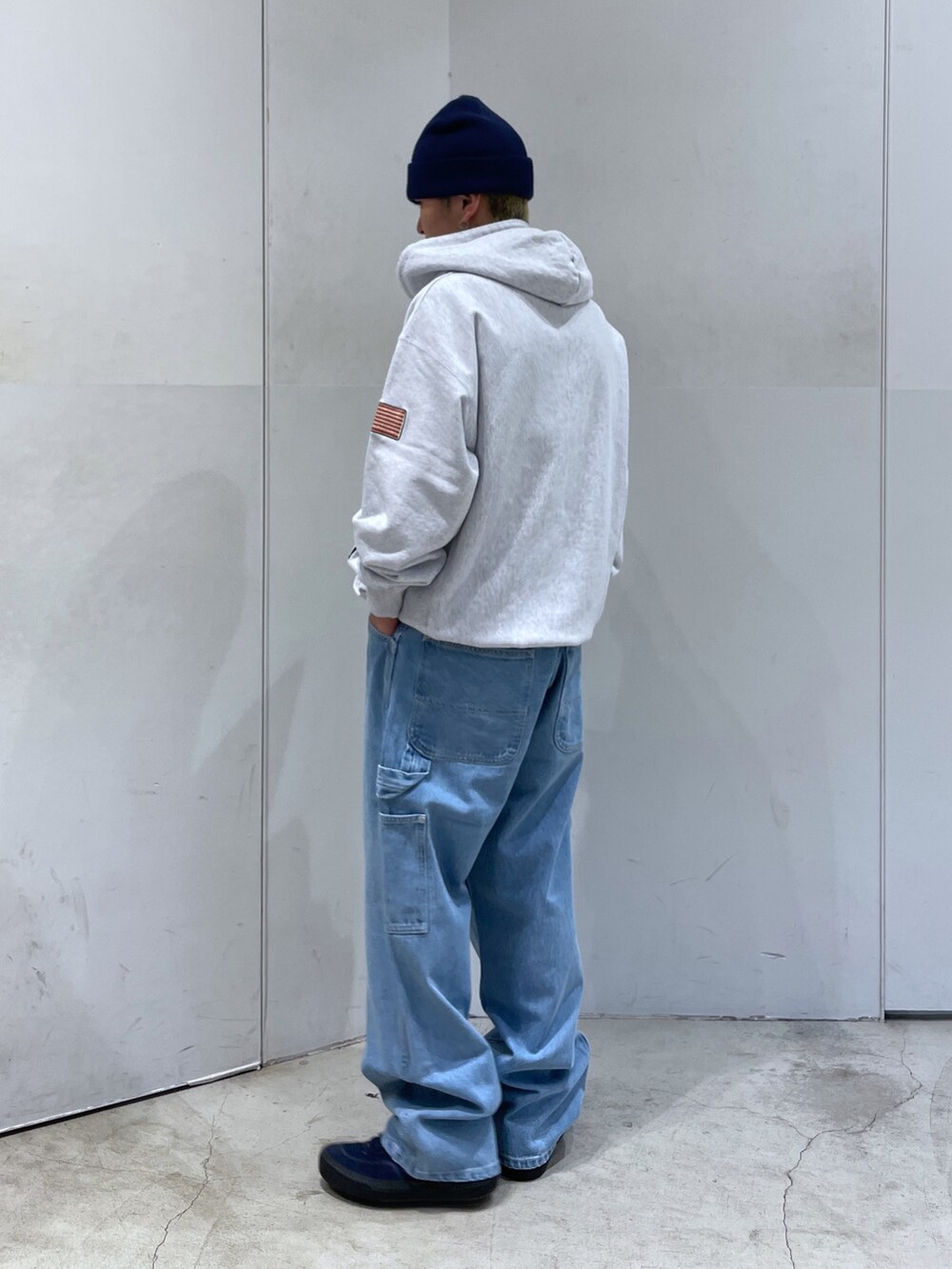 グレー系のパーカー、ブルー系のデニムパンツを着用したメンズの秋コーディネートの2枚目の写真