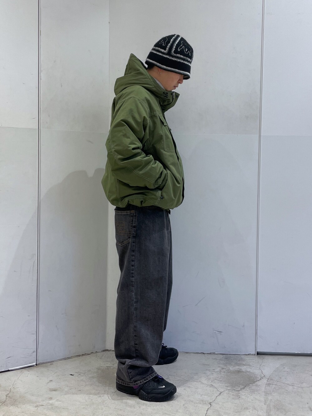 グリーン系のその他アウター、ブラック系のハットを着用したメンズの冬コーディネートの2枚目の写真
