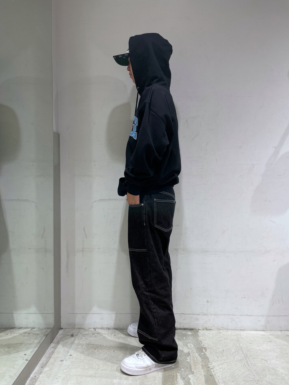ブラック系のパーカー、ブラック系のパンツ、ホワイト系のキャップを着用したメンズの秋コーディネートの4枚目の写真