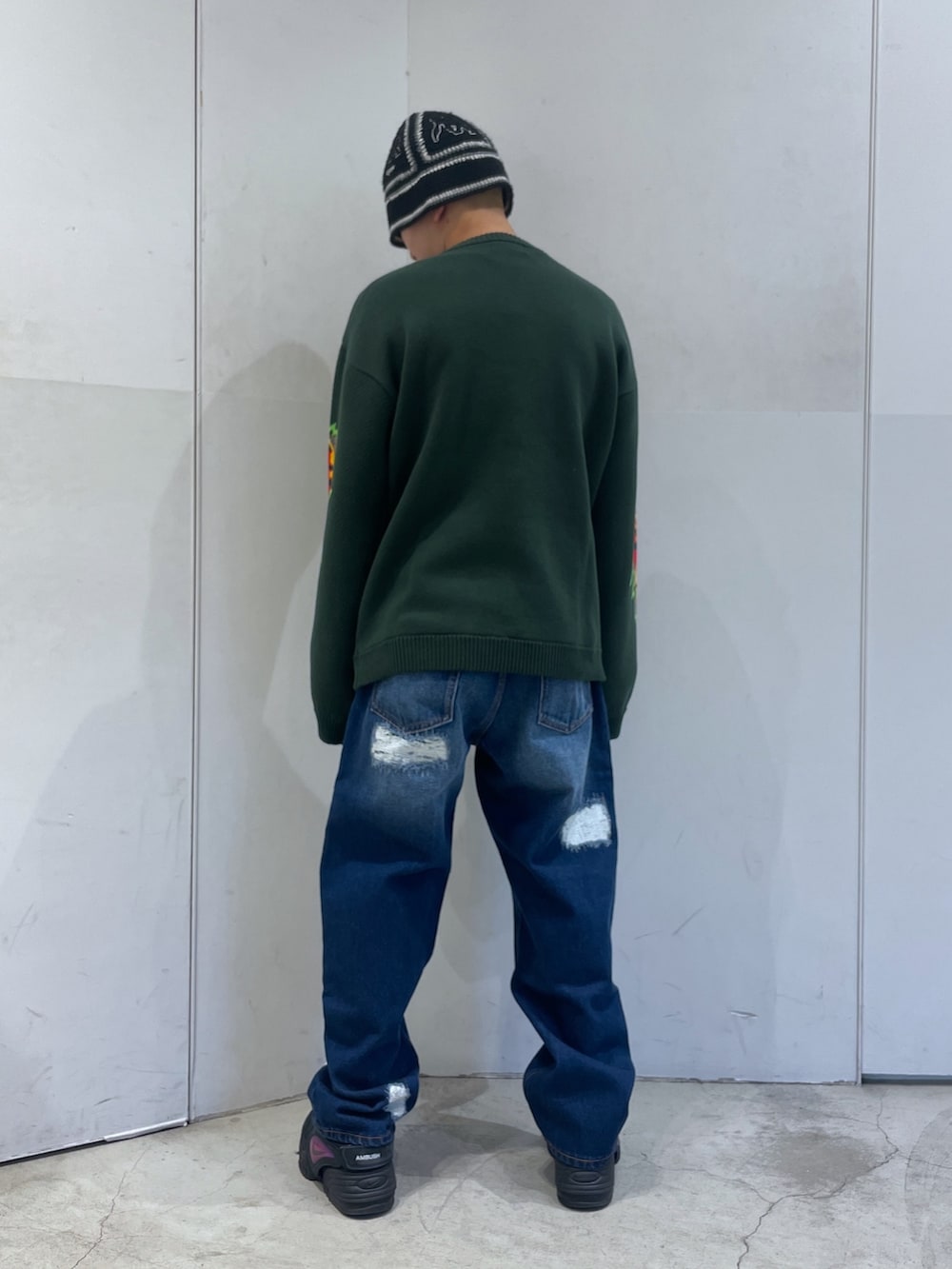 ブルー系のデニムパンツ、グリーン系のニット/セーターを着用したメンズの冬コーディネートの4枚目の写真