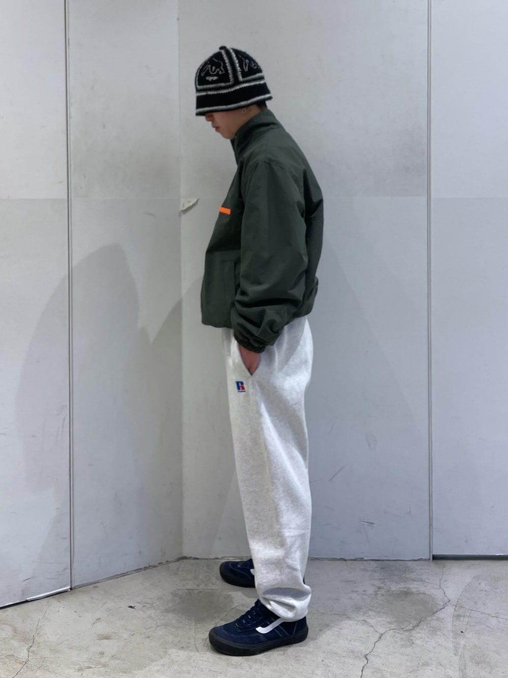 グリーン系のブルゾン、グレー系のスウェットパンツ、ブラック系のハットを着用したメンズの冬コーディネートの4枚目の写真