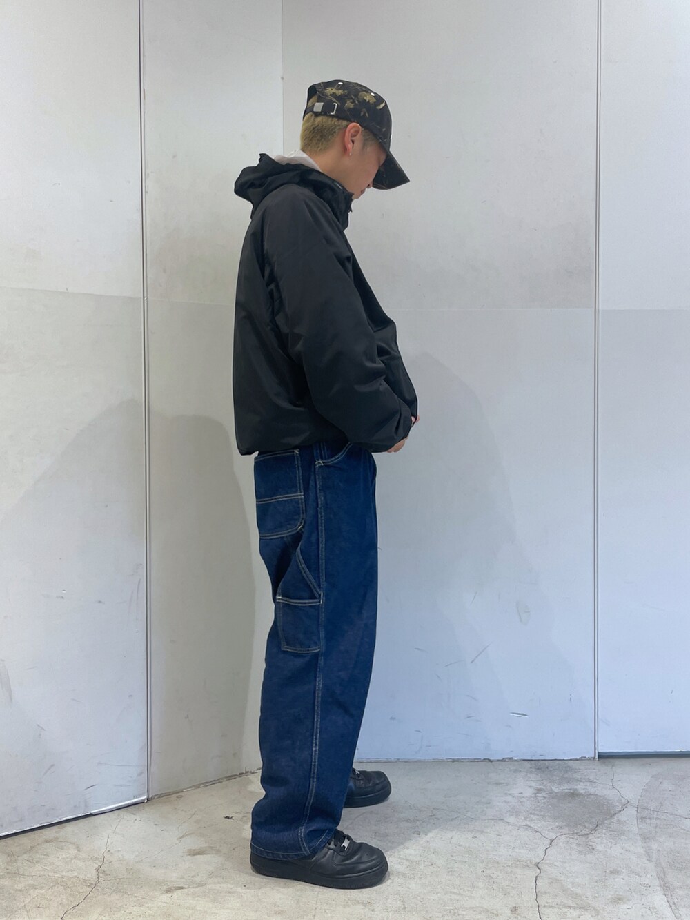 ブラック系のブルゾン、ブルー系のデニムパンツを着用したメンズの秋コーディネートの2枚目の写真