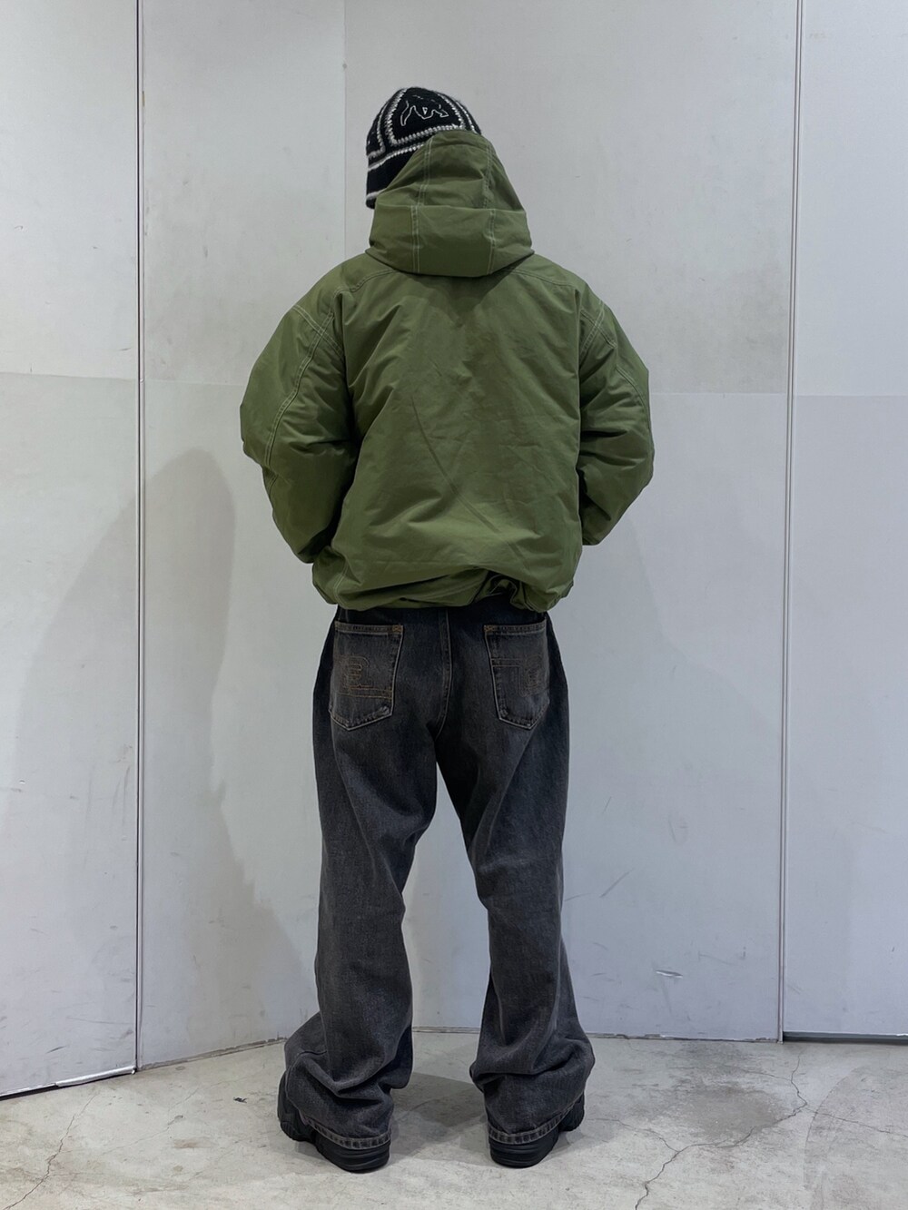 グリーン系のその他アウター、ブラック系のハットを着用したメンズの冬コーディネートの3枚目の写真