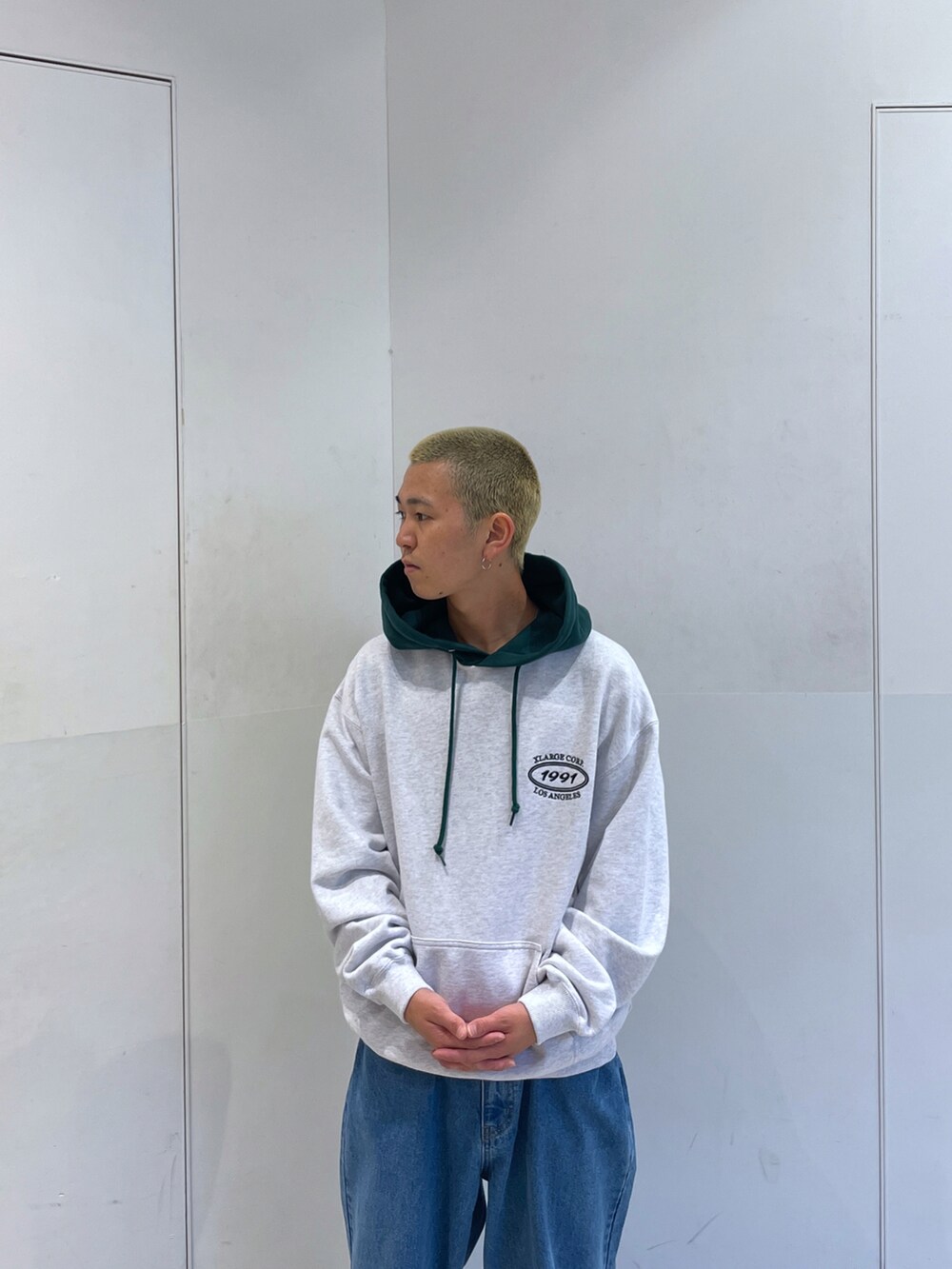 グレー系のパーカー、ブルー系のデニムパンツを着用したメンズの秋コーディネートの5枚目の写真