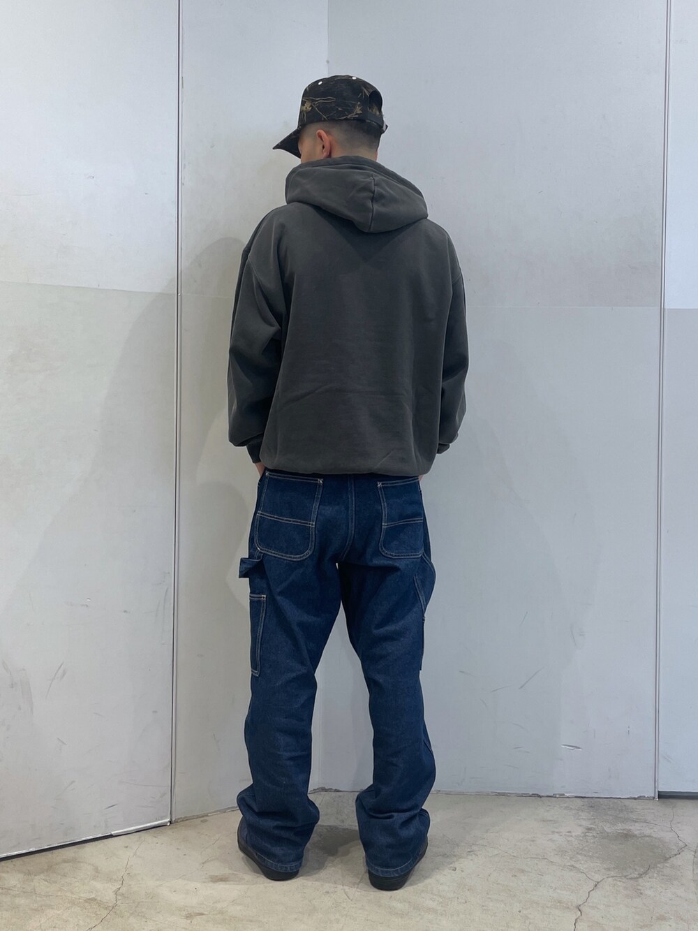 ブラック系のパーカー、ブルー系のデニムパンツを着用したメンズの秋コーディネートの3枚目の写真