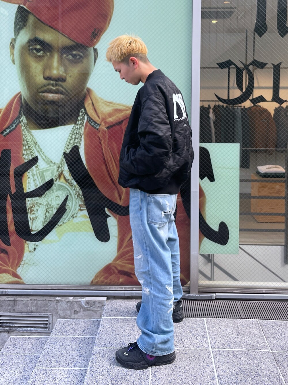 ブラック系のブルゾン、ブルー系のデニムパンツを着用したメンズの冬コーディネートの4枚目の写真