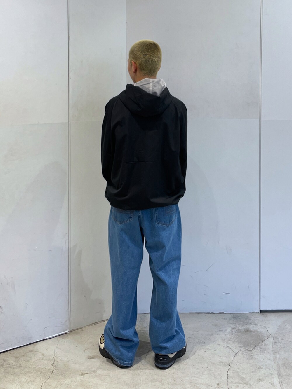 ブラック系のブルゾン、ブルー系のデニムパンツを着用したメンズの秋コーディネートの5枚目の写真