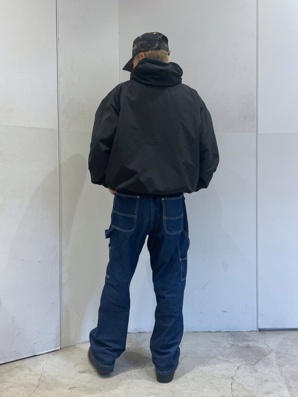 ブラック系のブルゾン、ブルー系のデニムパンツを着用したメンズの秋コーディネートの3枚目の写真