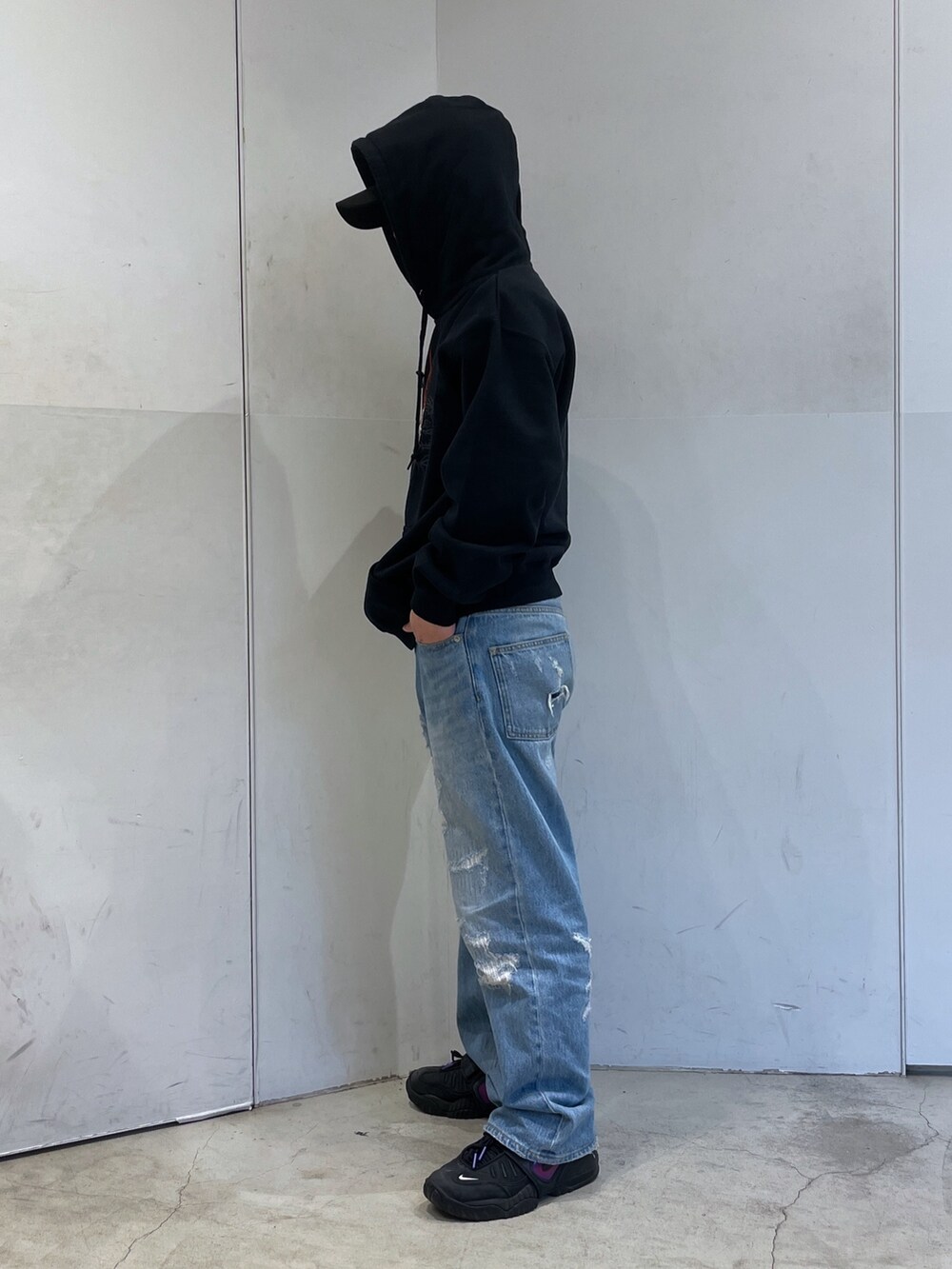 ブラック系のパーカー、ブルー系のデニムパンツを着用したメンズの冬コーディネートの4枚目の写真