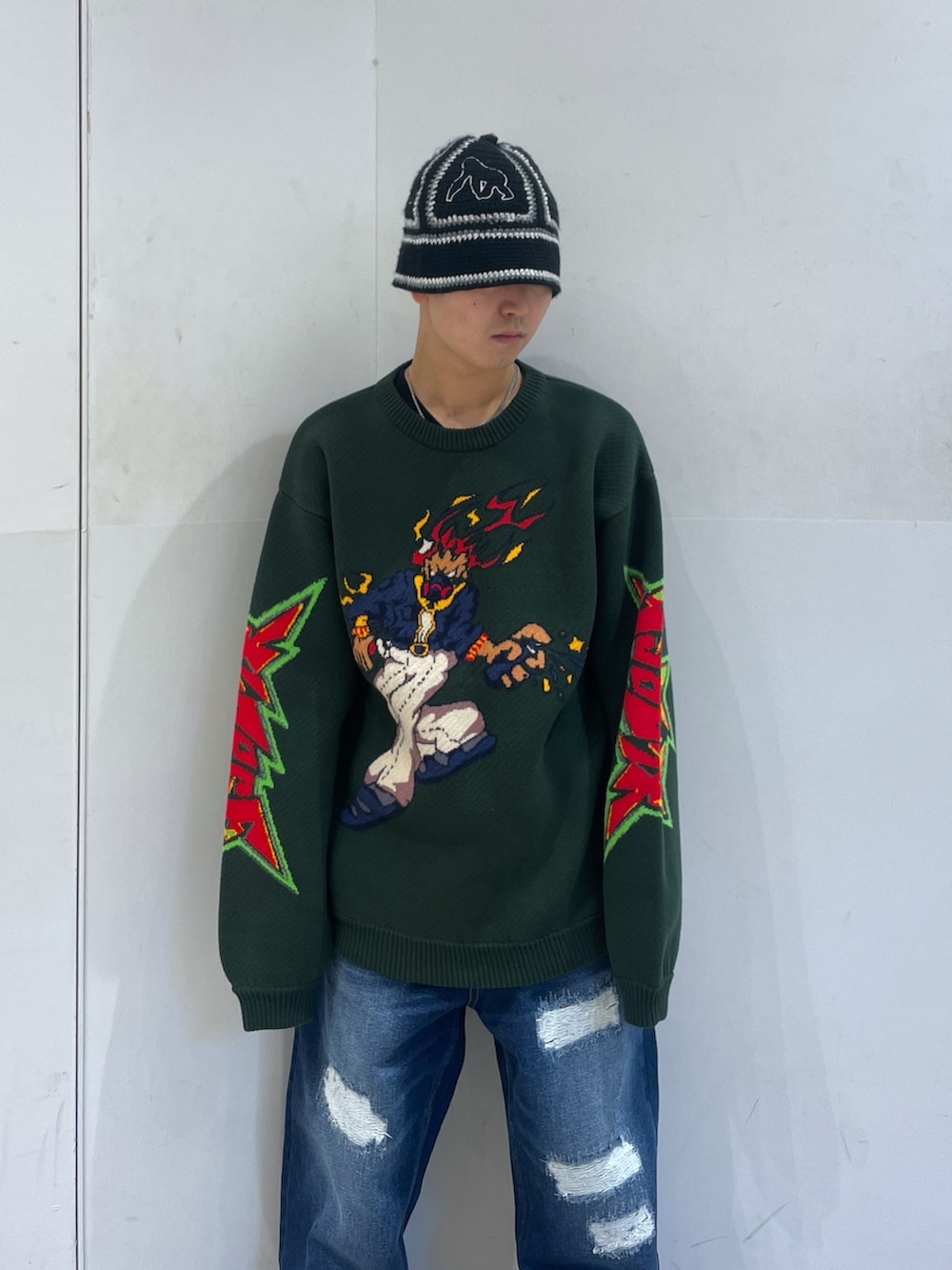 ブルー系のデニムパンツ、グリーン系のニット/セーターを着用したメンズの冬コーディネートの7枚目の写真