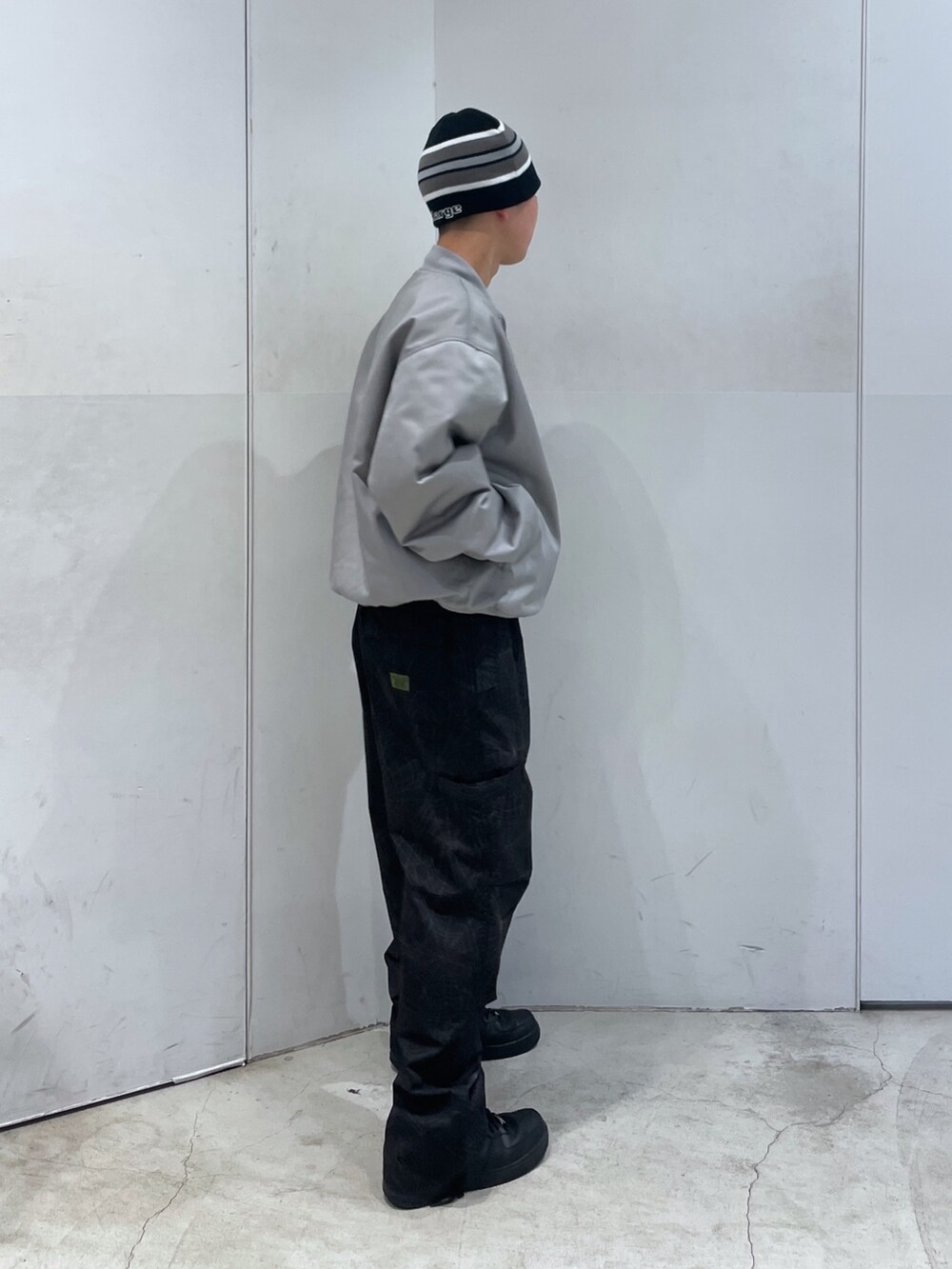 グレー系のブルゾン、ブラック系のその他パンツ、ブラック系のニットキャップ/ビーニーを着用したメンズの冬コーディネートの2枚目の写真